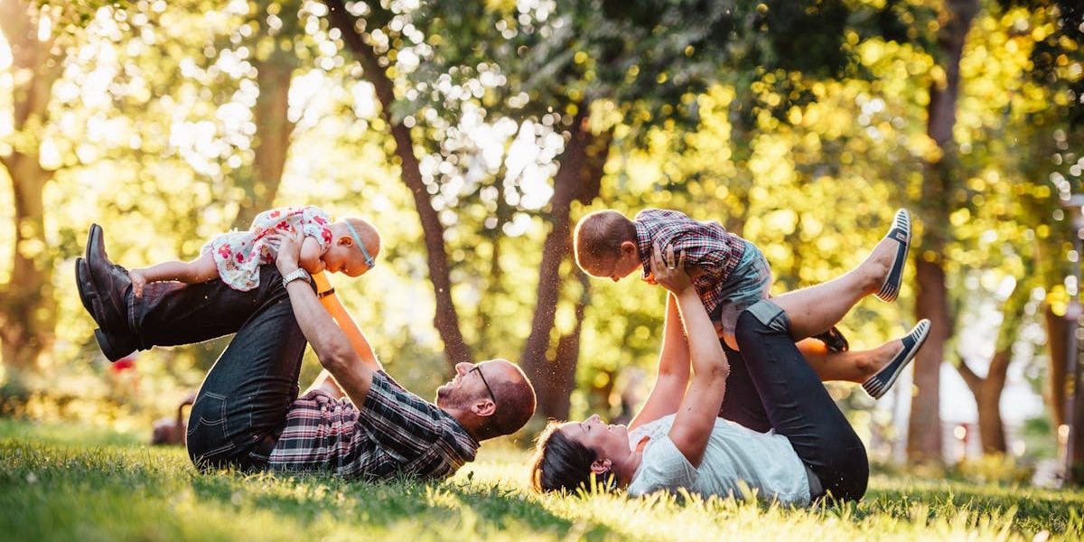 A joyful family enjoying playtime in a sunny park, capturing moments of laughter and happiness.