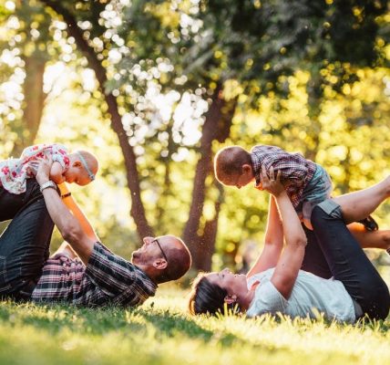 A joyful family enjoying playtime in a sunny park, capturing moments of laughter and happiness.