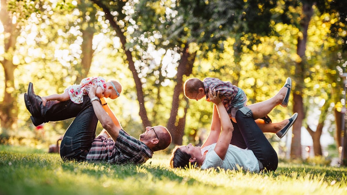 A joyful family enjoying playtime in a sunny park, capturing moments of laughter and happiness.